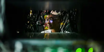 close up view of a woman wearing glasses working in a data center
