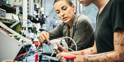 Female technician guiding young trainee