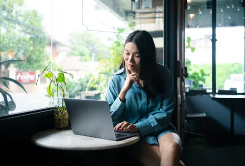 woman at a cafe looking at laptop computer