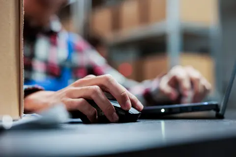 a close up one hand on a keyboard the other on a mouse